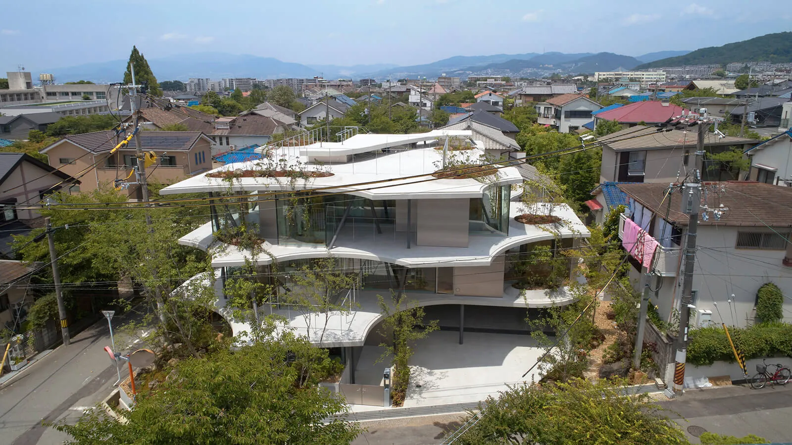 一座現代多層住宅建築,擁有玻璃牆面與混凝土外觀。