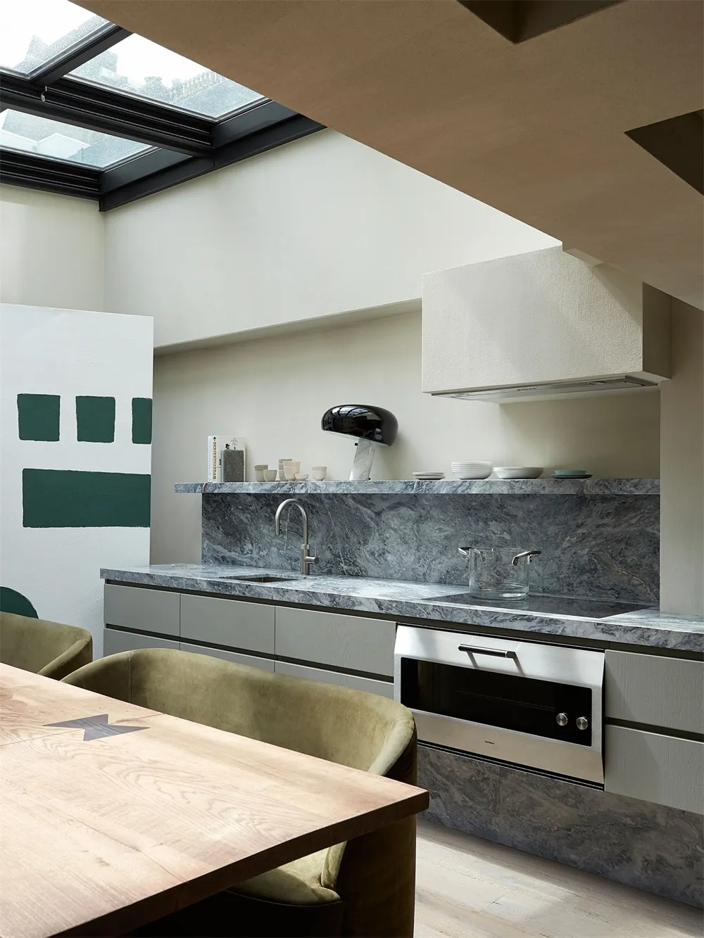 A modern residential kitchen featuring marble countertops and backsplash.