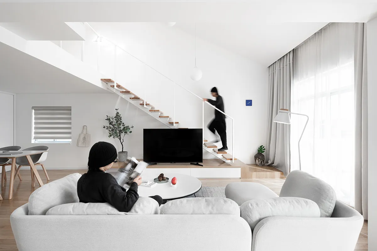 A modern minimalist living room featuring neutral tones and a clean, uncluttered design.