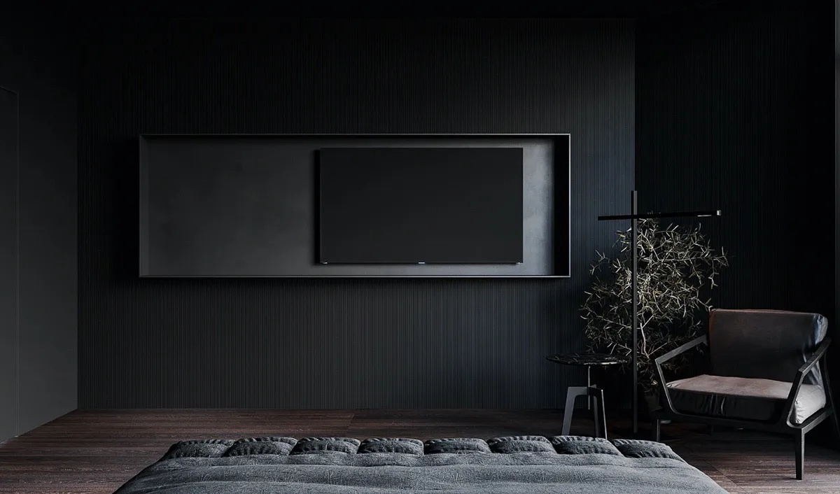A minimalist bedroom with a dark color palette, featuring a bed with textured bedding, a wall-mounted flat-screen TV, and a s