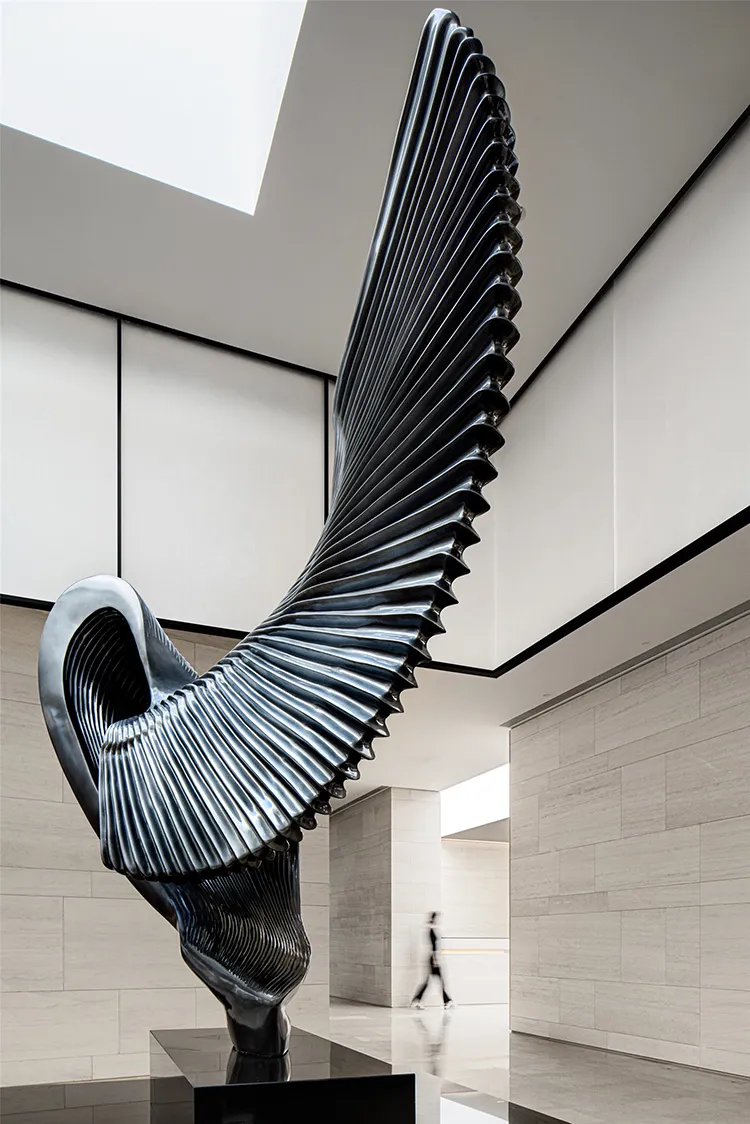 A modern metal sculpture with a sleek, flowing design.