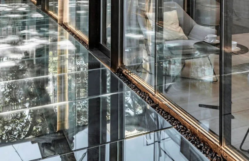 A minimalist residential interior with large glass windows.