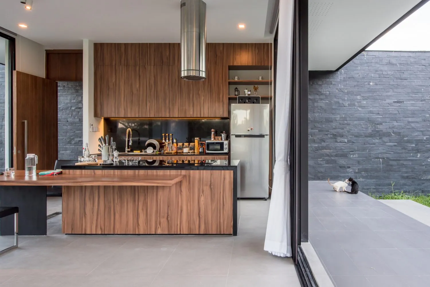 Modern residential kitchen with wooden cabinetry and stainless steel appliances.