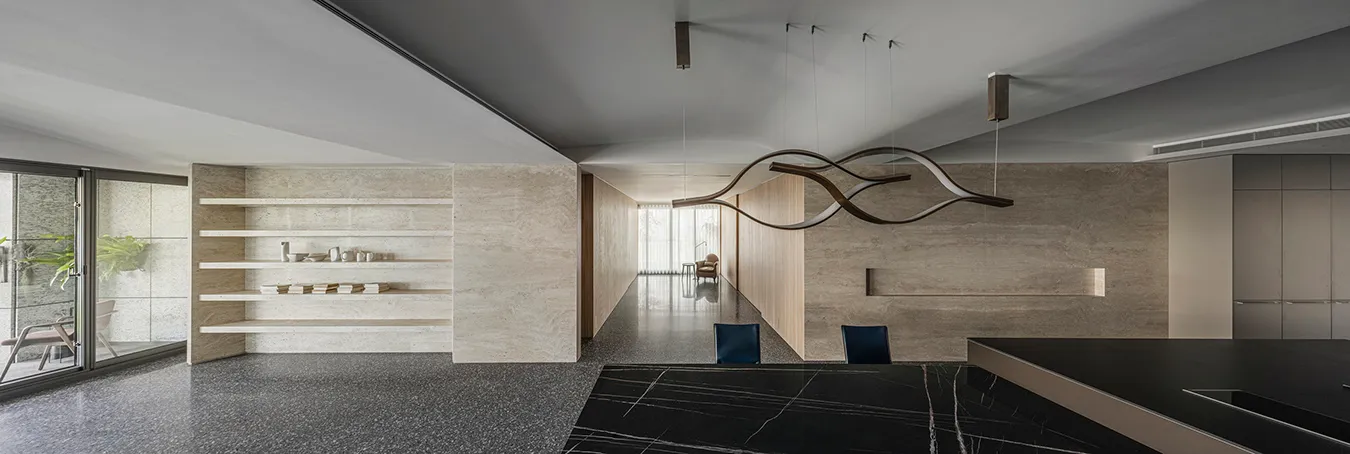 Modern minimalist living area with concrete walls and marble countertops.