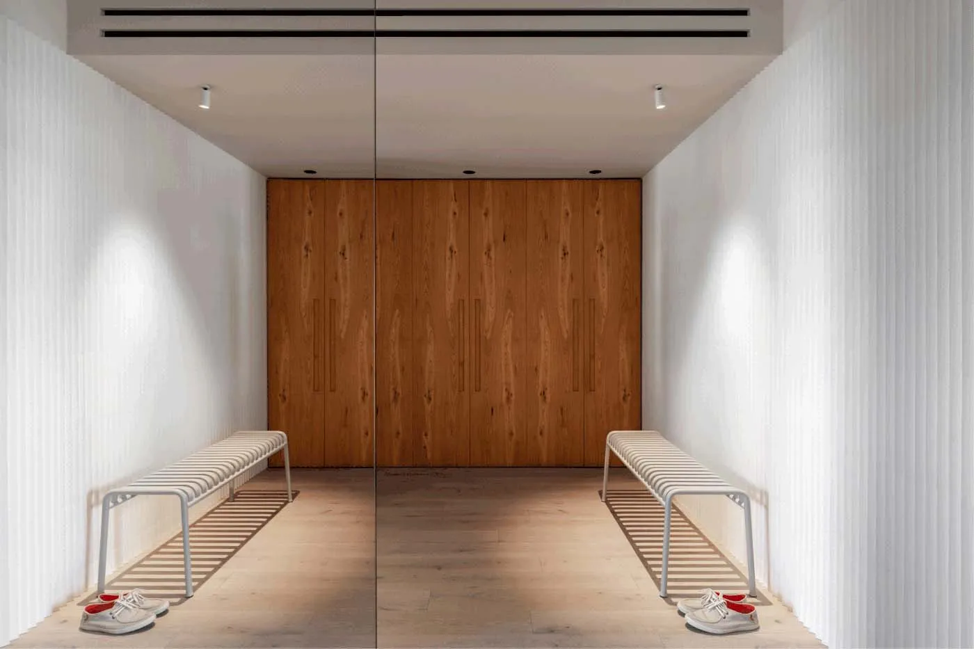A modern entrance featuring a wooden door and benches.