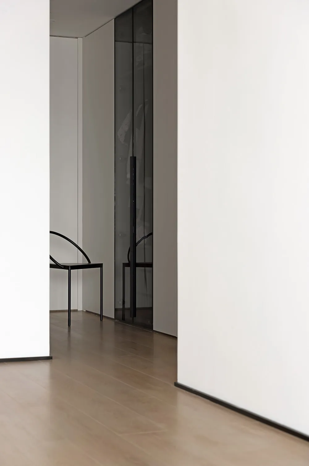 Modern minimalist room featuring a glass door and minimalist furniture.