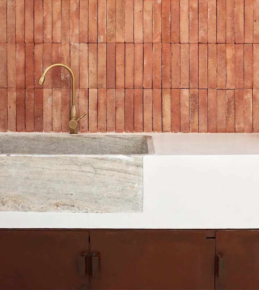 Minimalist kitchen with industrial-style metal faucet and concrete stone sink
