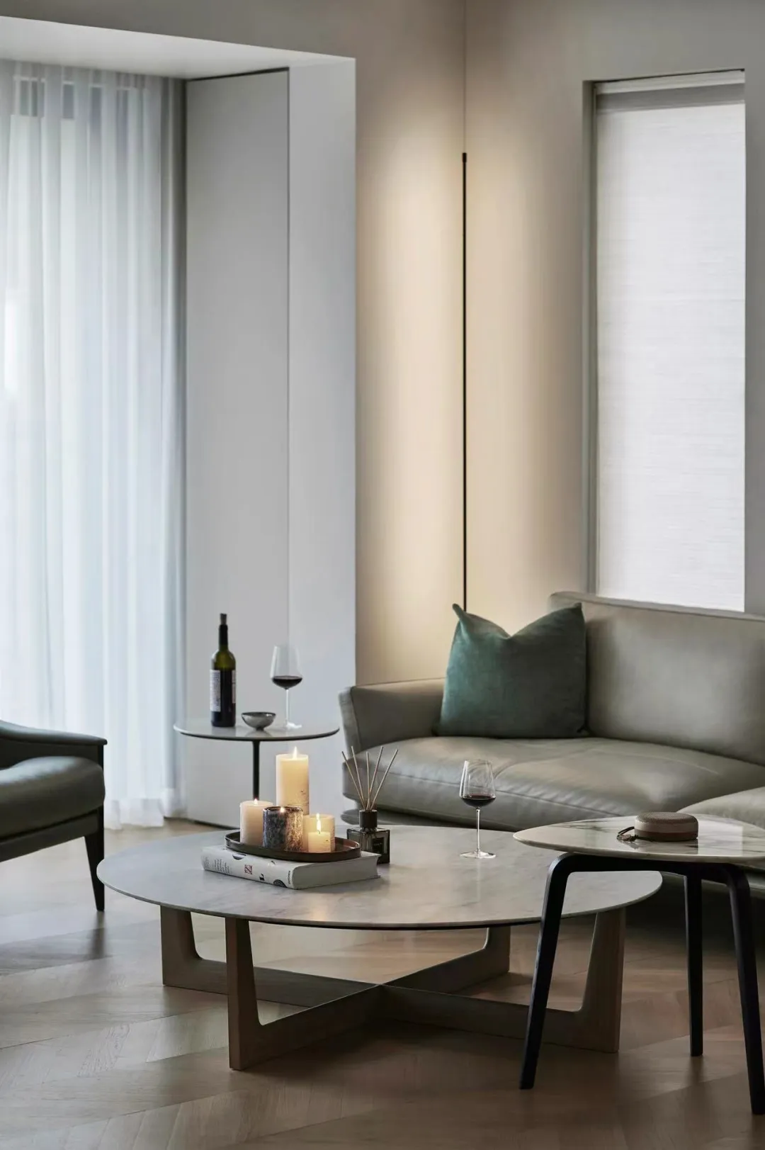 A minimalist living room featuring marble coffee tables and a leather sofa.