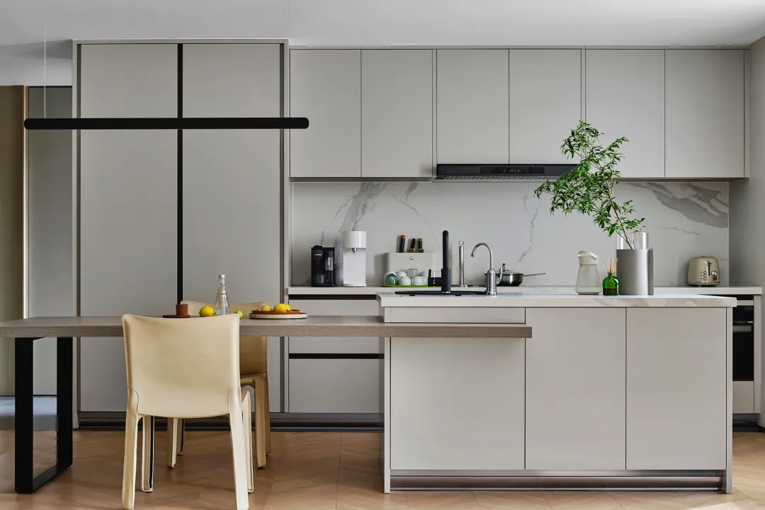 A modern kitchen with a marble countertop and matte-finished cabinets.