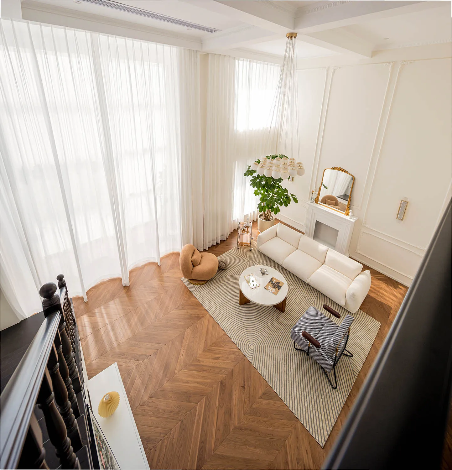 Modern minimalist living room featuring a white sofa, a brown accent chair, and a round coffee table on a striped rug, with a