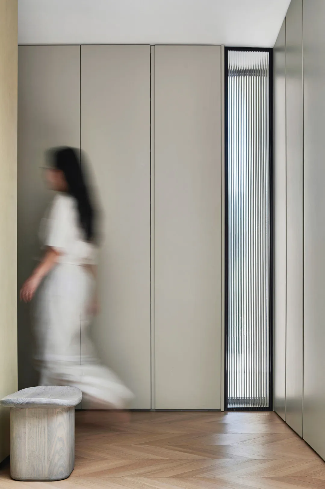 A minimalist interior design featuring metallic surfaces and translucent glass elements.