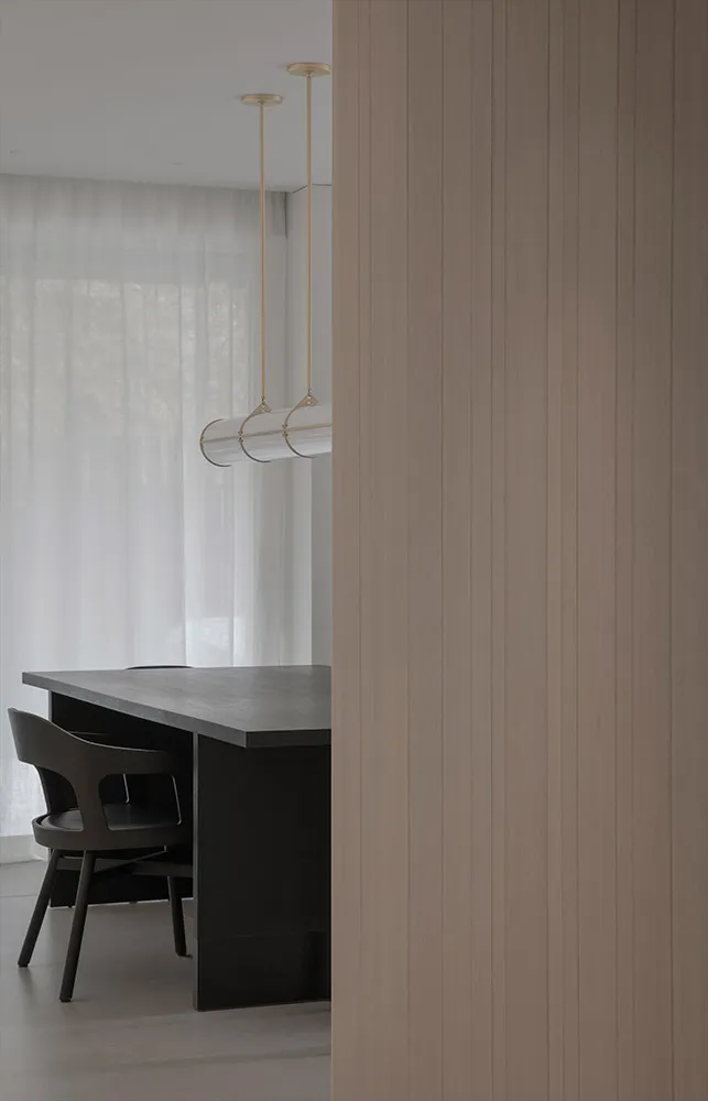 A modern dining room with a concrete table and minimalist design features.