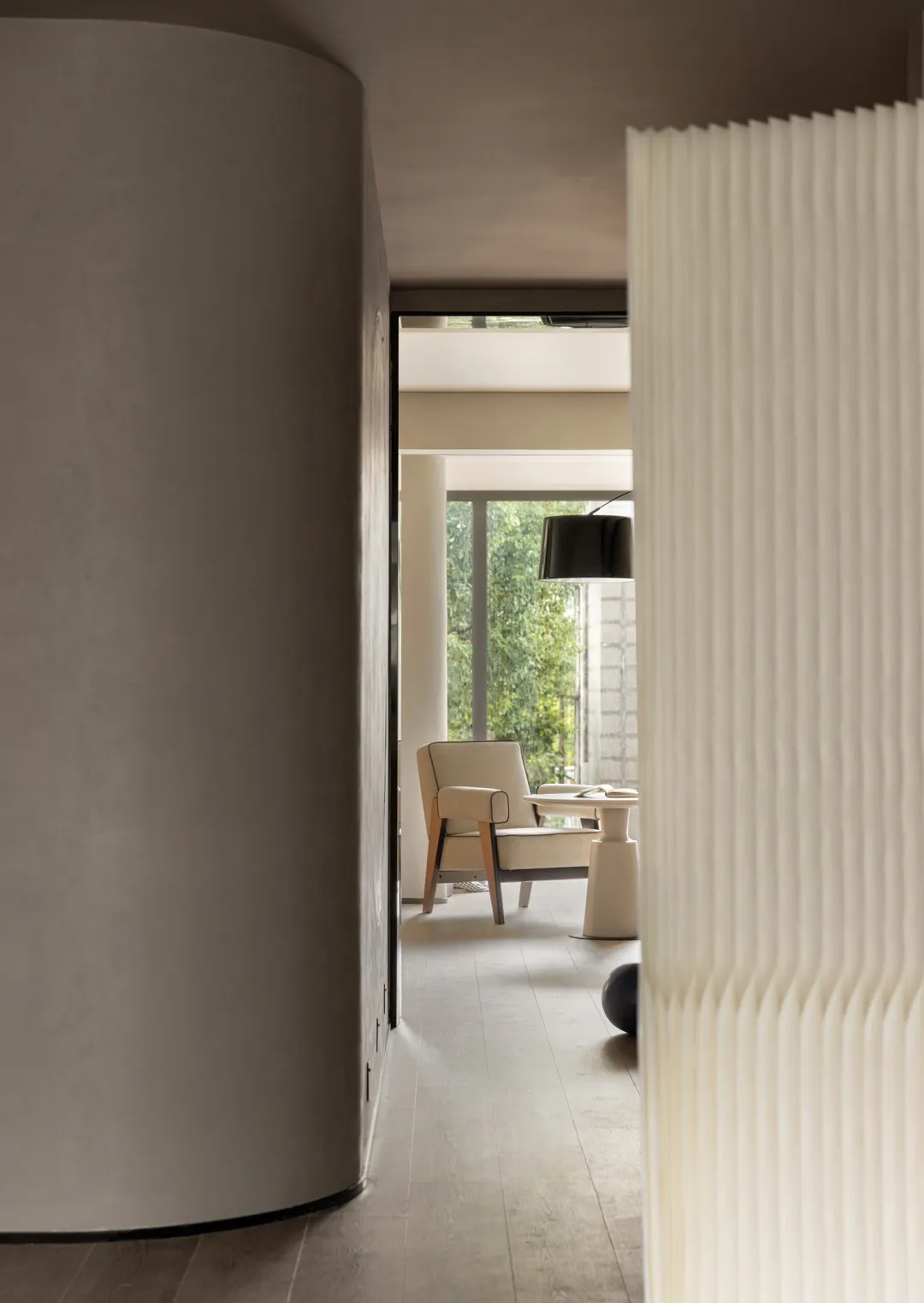 Modern minimalist living room featuring a white curtain and column.