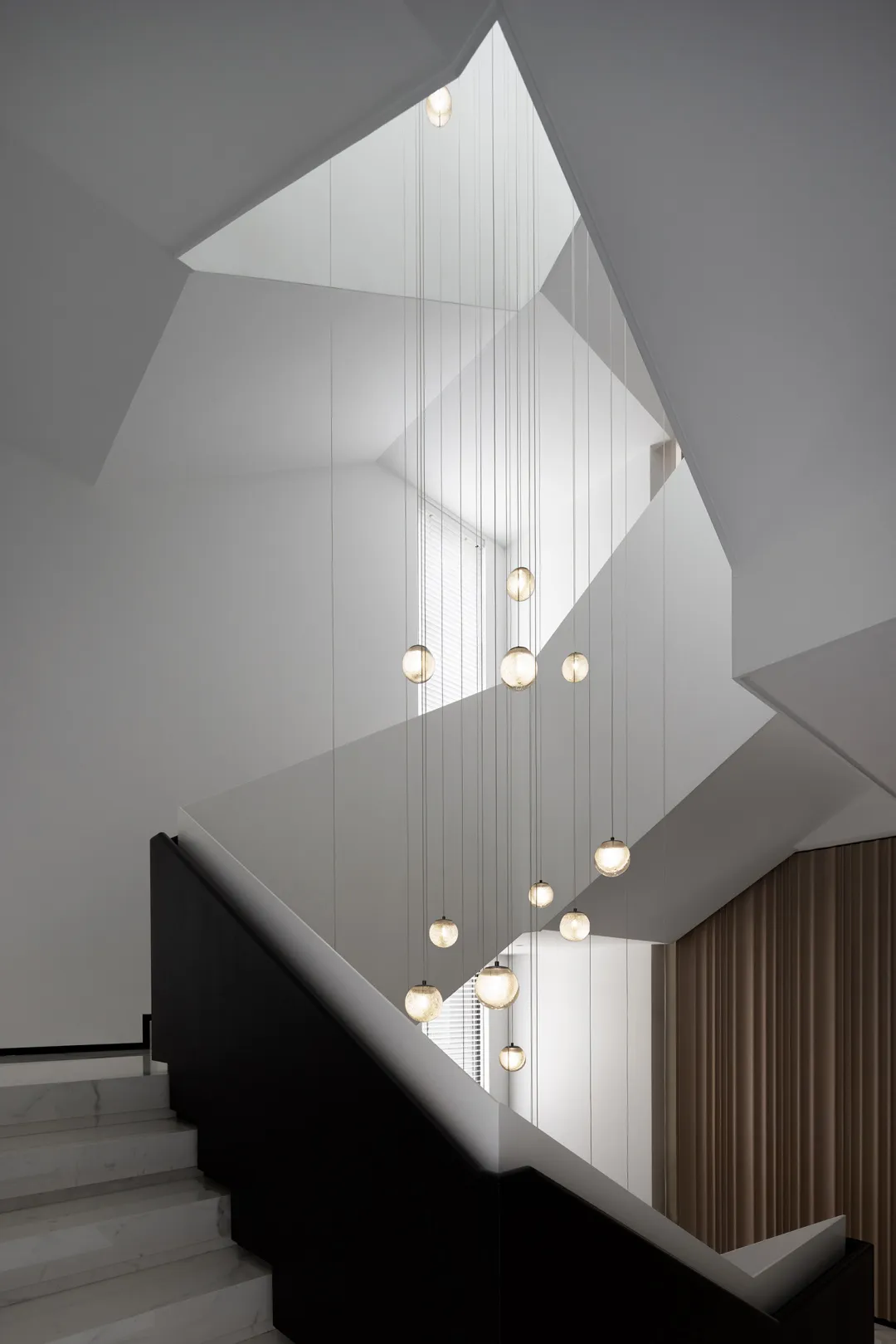 A modern minimalist staircase with glass lighting fixtures