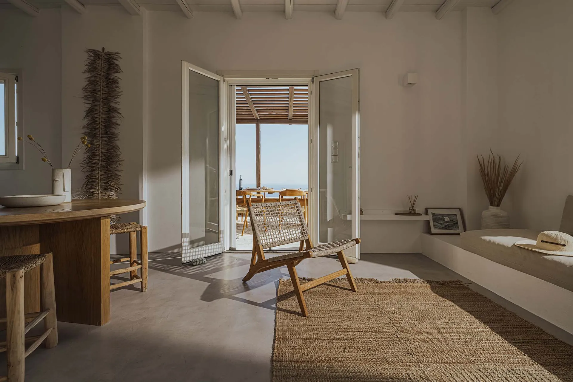 A minimalist residential interior featuring wood furniture and woven textiles.