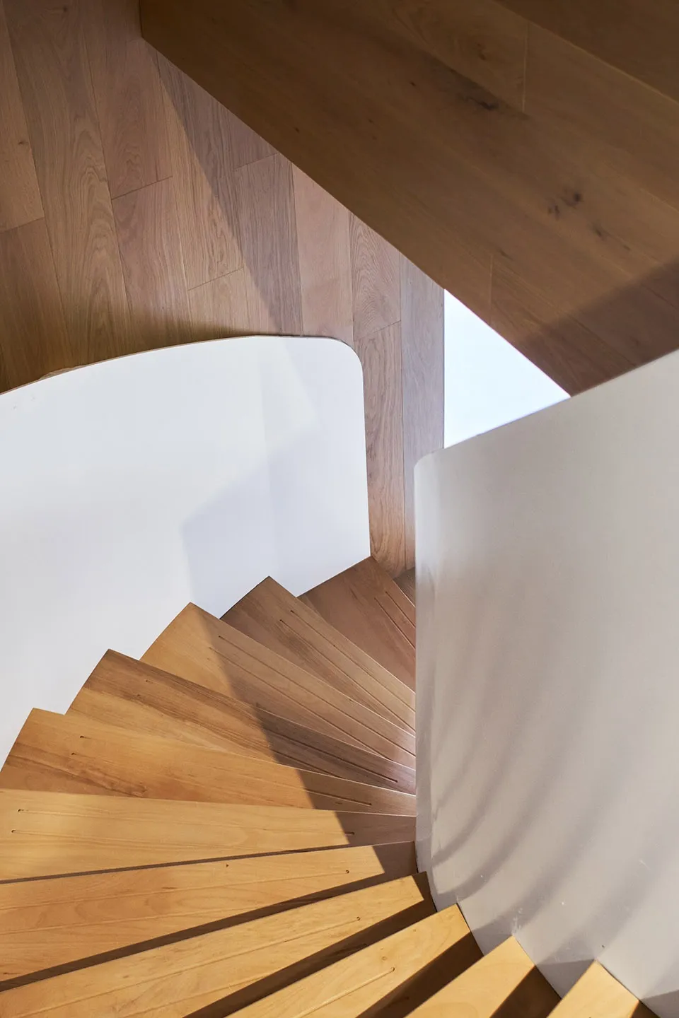 A modern staircase with wooden steps and railings.