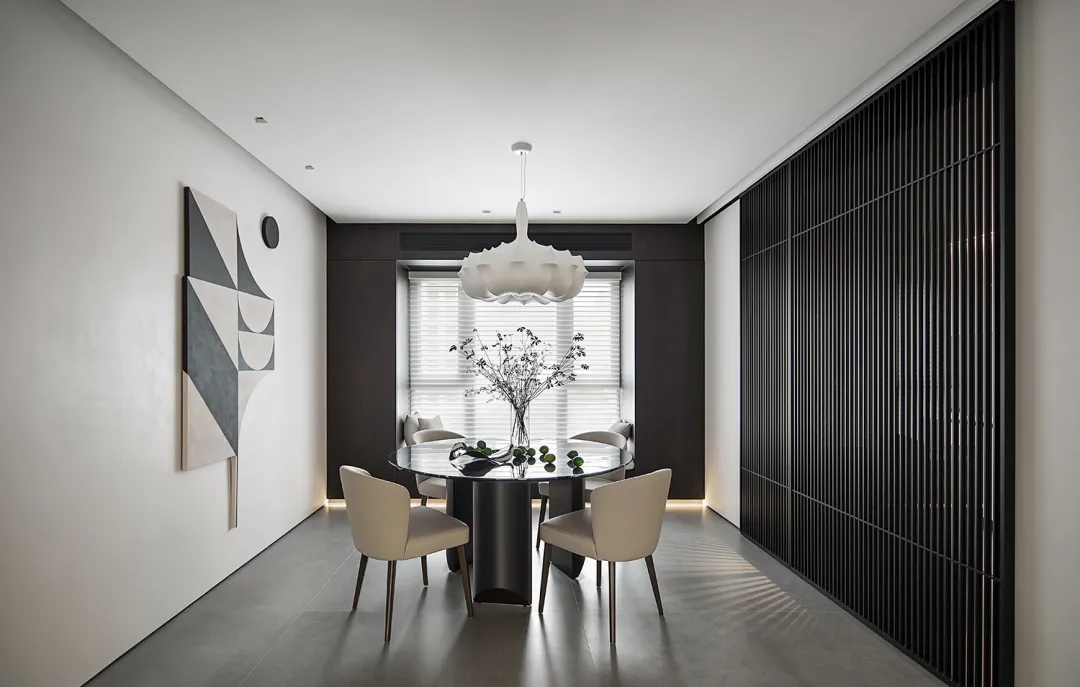 Modern dining room with a glass top dining table, wooden chairs, and a metal pendant light.