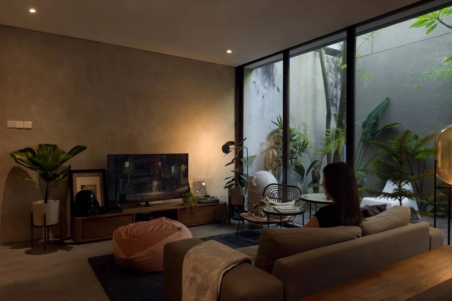 A modern living room with concrete walls and live plants