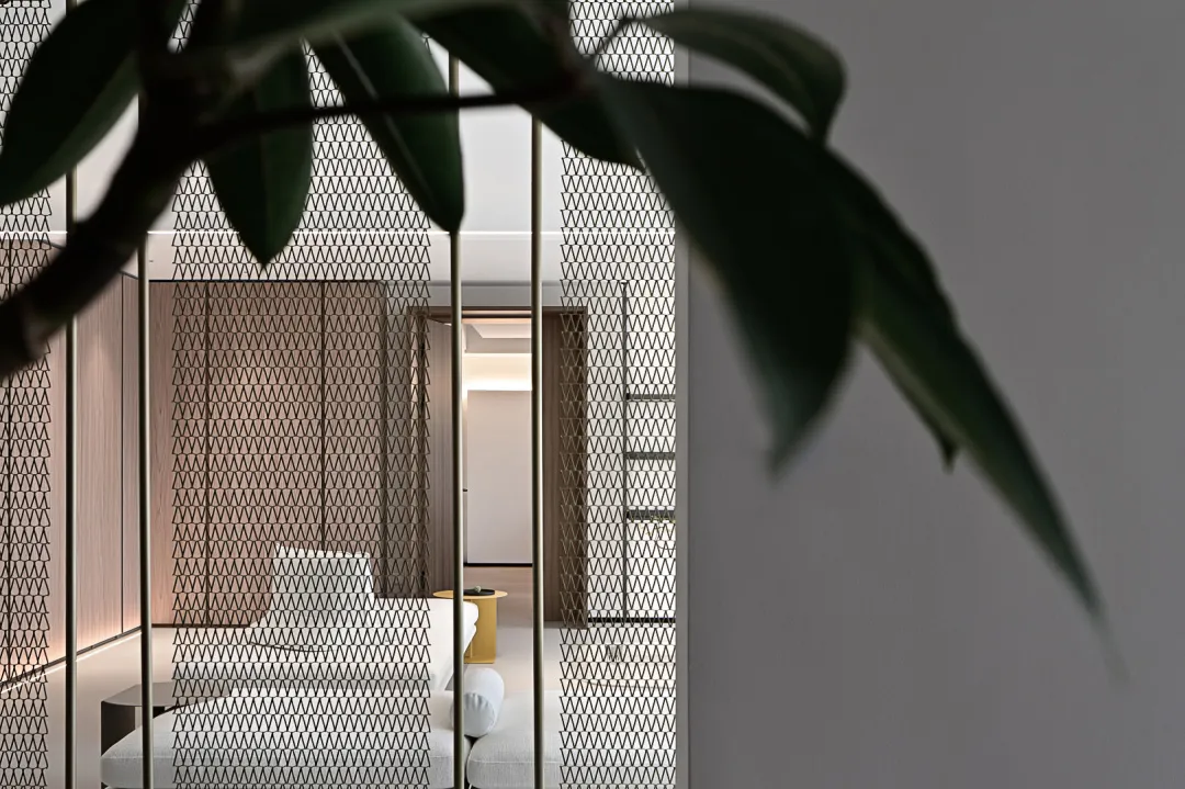 A modern living room with textured wallpaper, featuring a sleek sofa and contemporary decor.