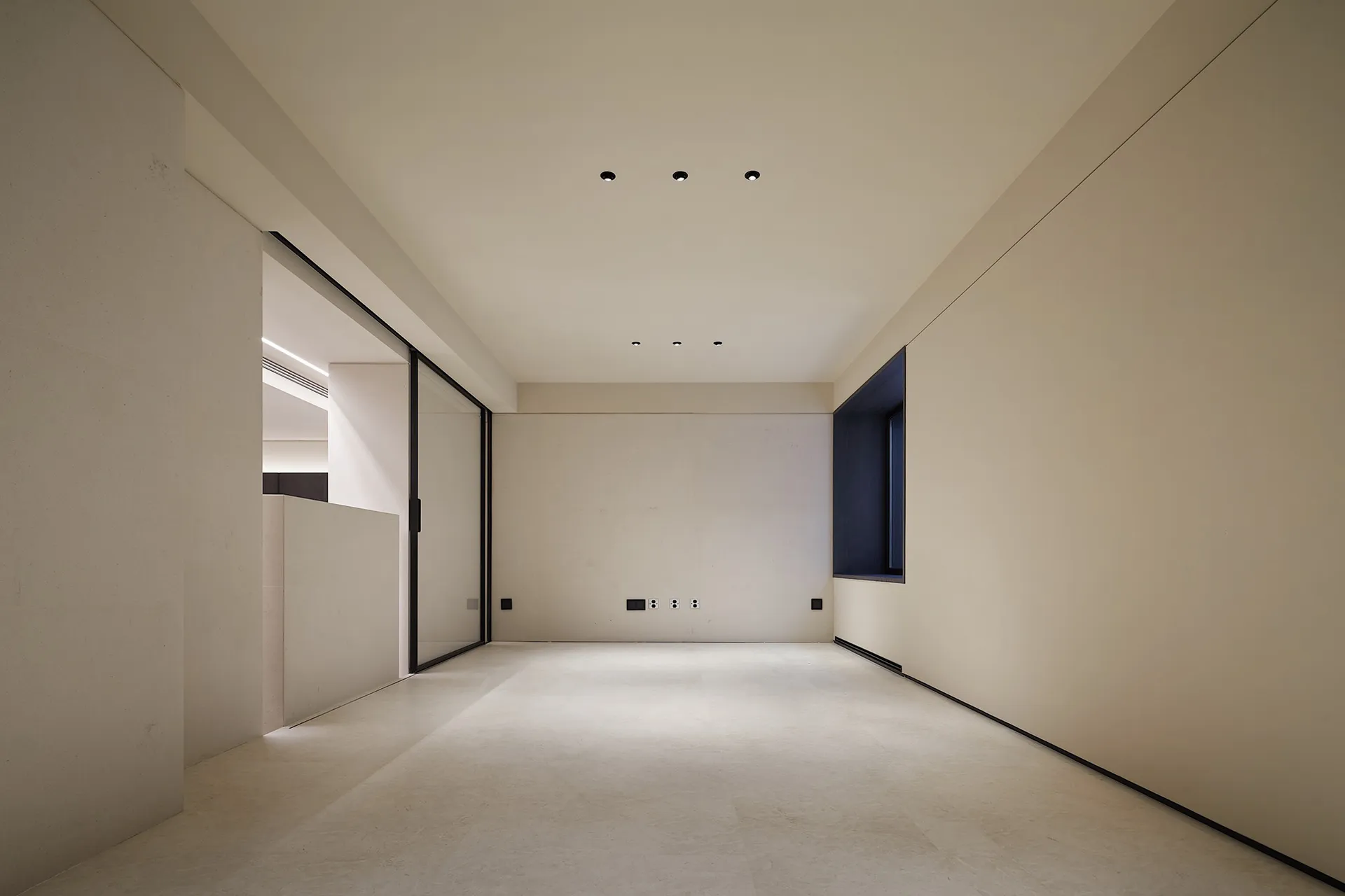 An empty minimalist interior space featuring concrete walls and floor.