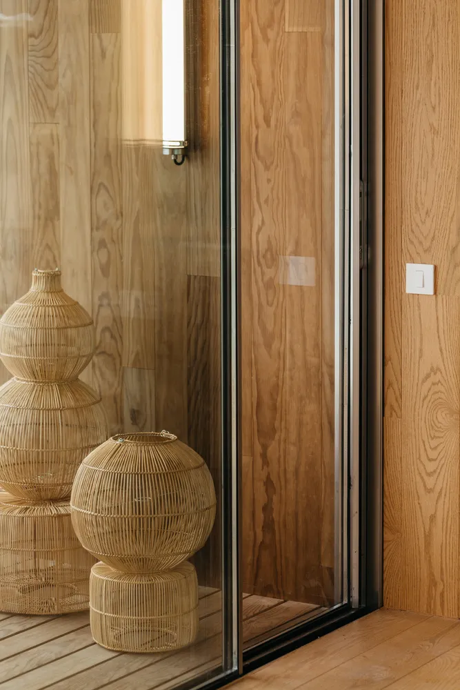 Modern bathroom featuring wooden paneling with a glass sliding door.