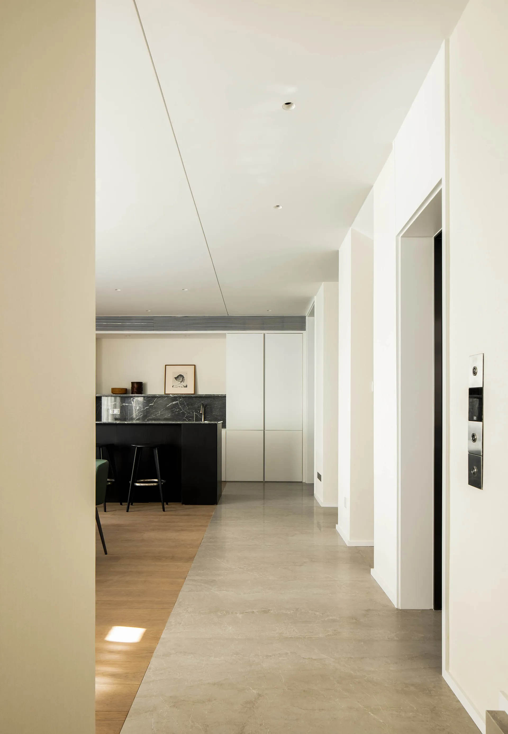 A modern interior space featuring a sleek concrete floor and a striking marble kitchen counter.