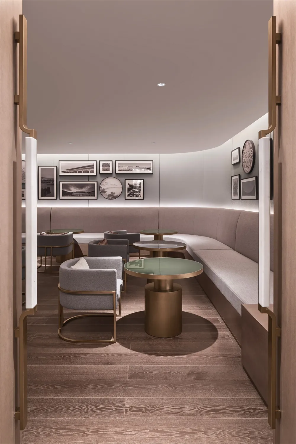 A modern restaurant-cafe with neutral textiles, bronze tables, and glass-top tables.