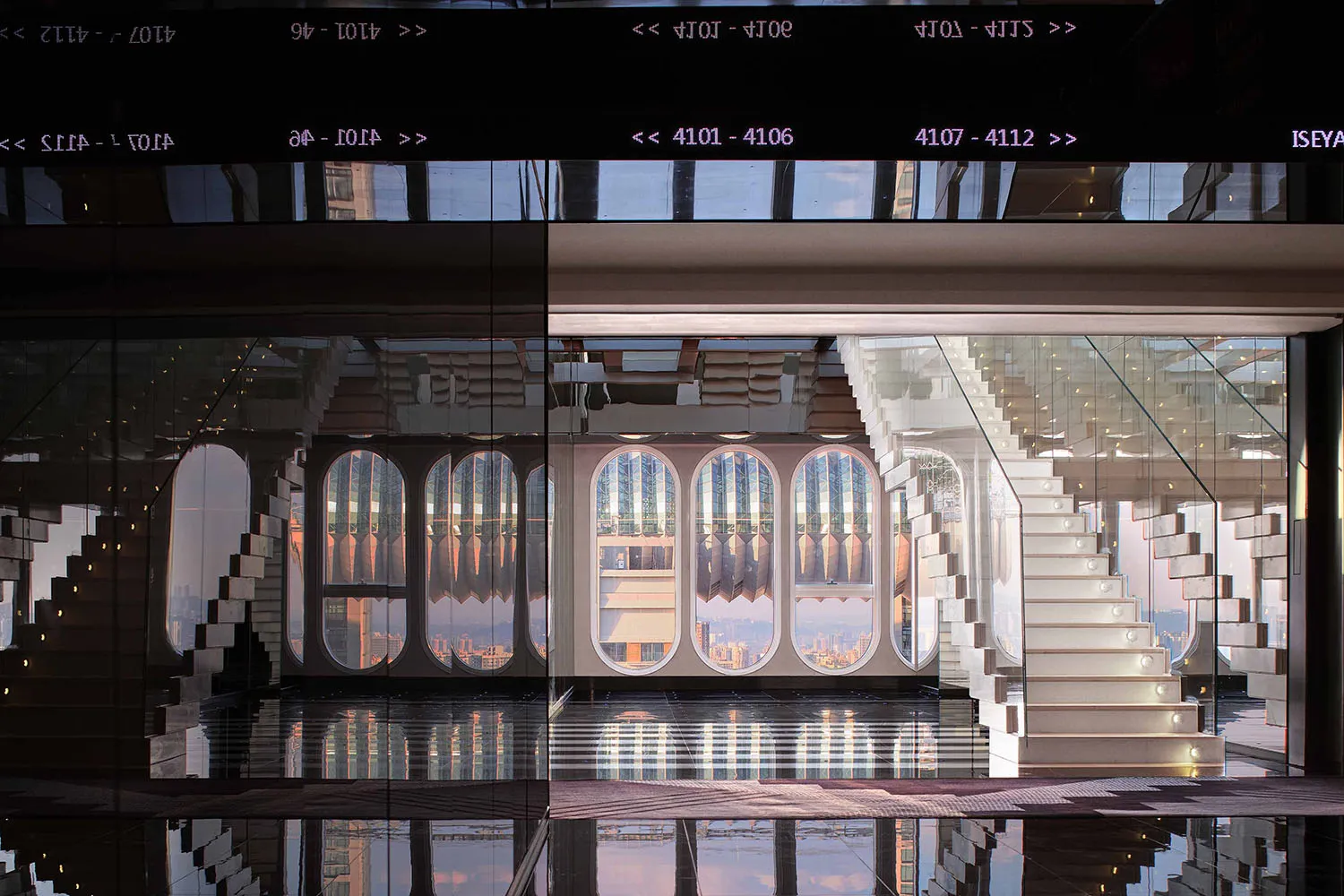 Staircase made of glass with concrete steps leading up to a glass wall