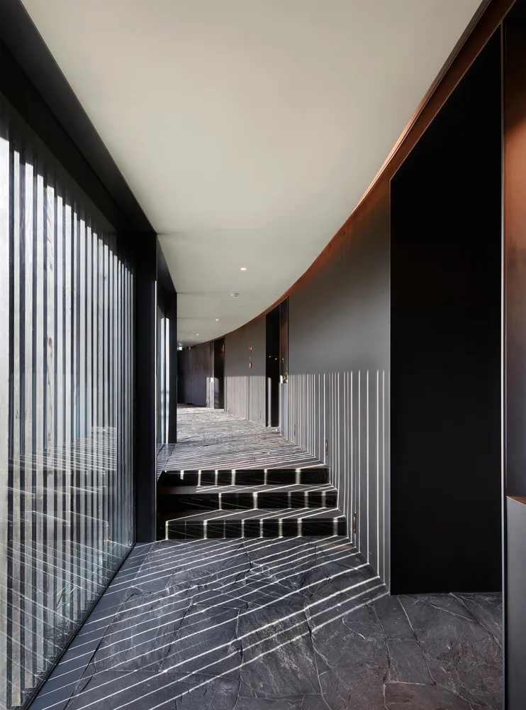 A black and white hallway with a staircase leading to another level, featuring two sets of steps and a sense of depth and dimension