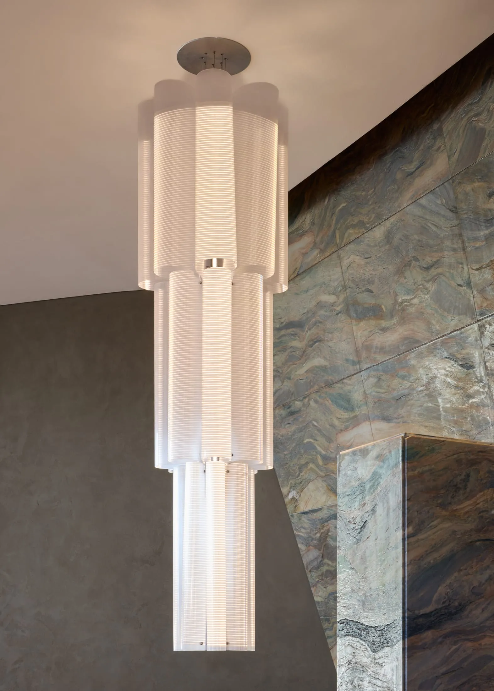 A modern room with stone walls, a large white light fixture, and a warm atmosphere