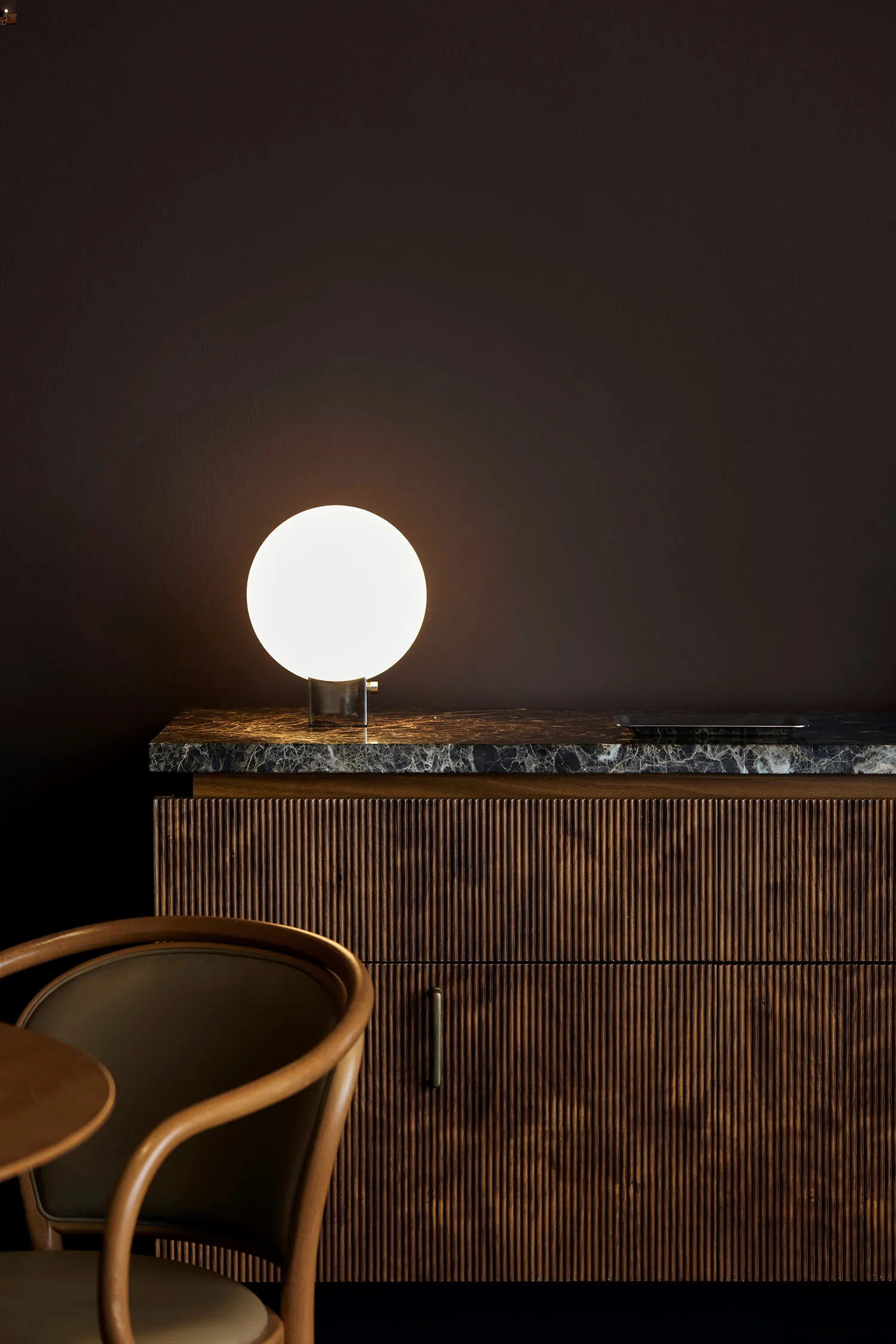 A wooden cabinet with a decorative light on top, featuring a drawer and a warm, inviting atmosphere