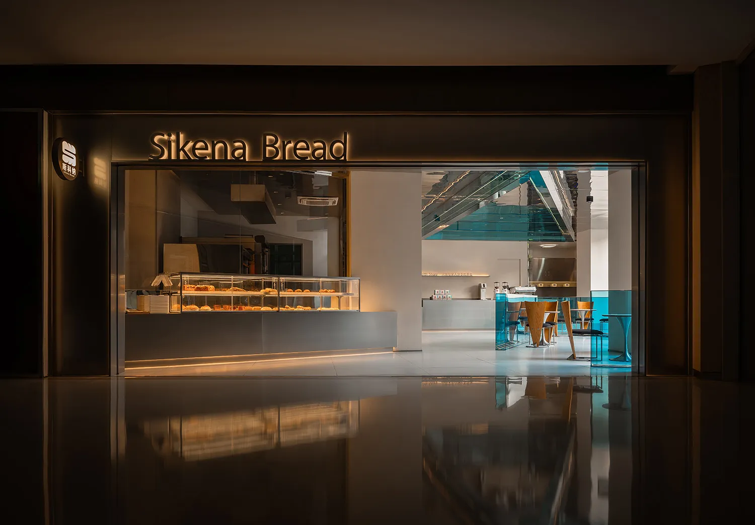 A modern cafe with a large window, seating areas, and natural light