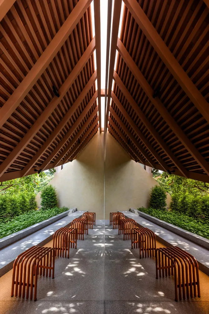 A long hallway with wooden benches and chairs, creating a calm and inviting atmosphere with warm wooden elements