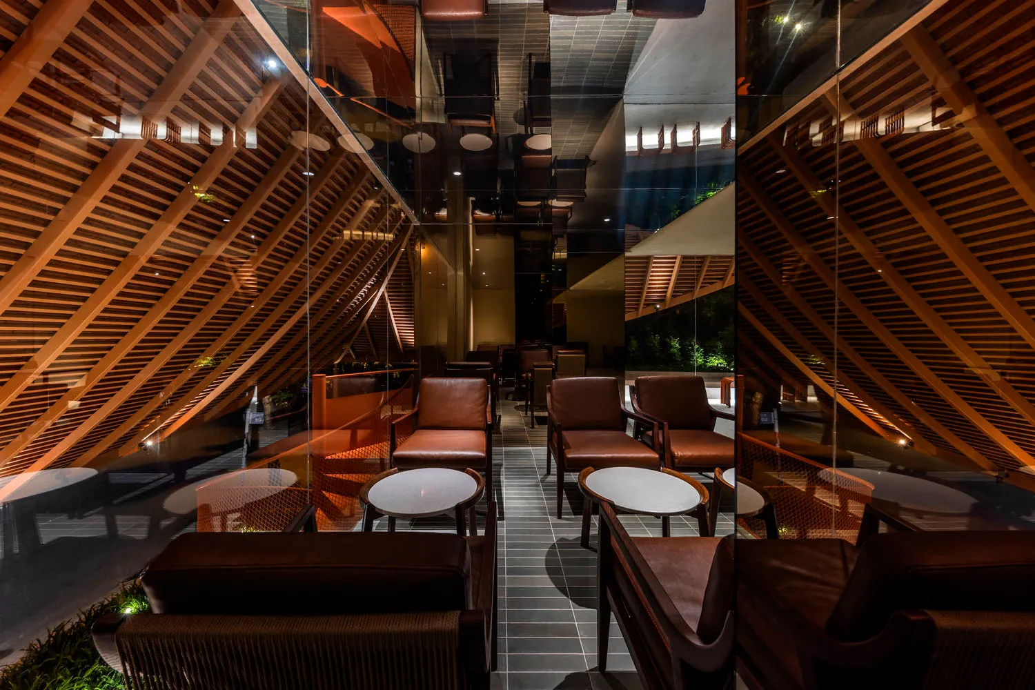 A warm and inviting cafe with brown and orange tones, featuring a mix of chairs, couches, and dining tables, perfect for relaxation and conversation