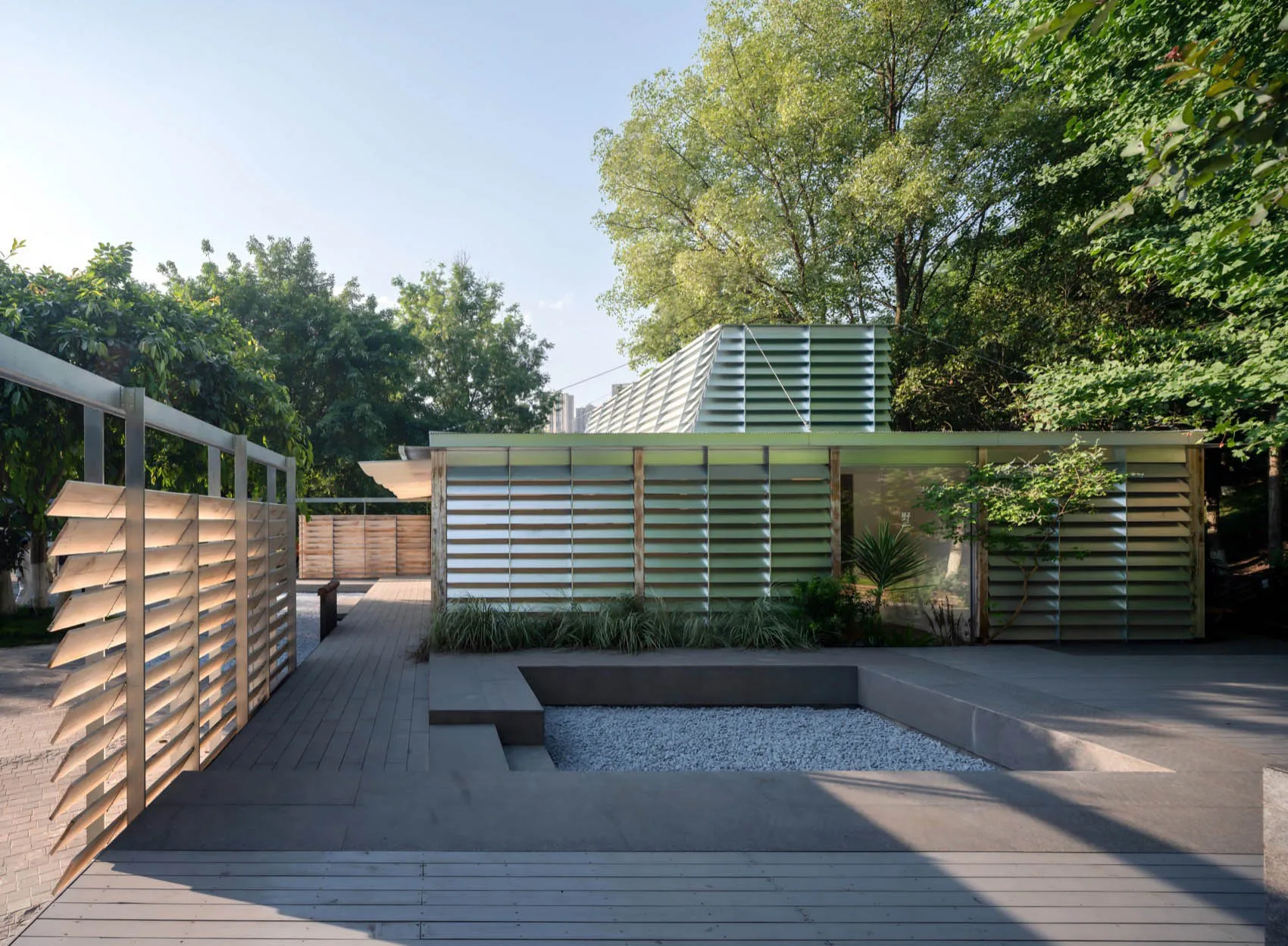 A modern house with a large glass wall, wood and glass elements, and abundant natural light