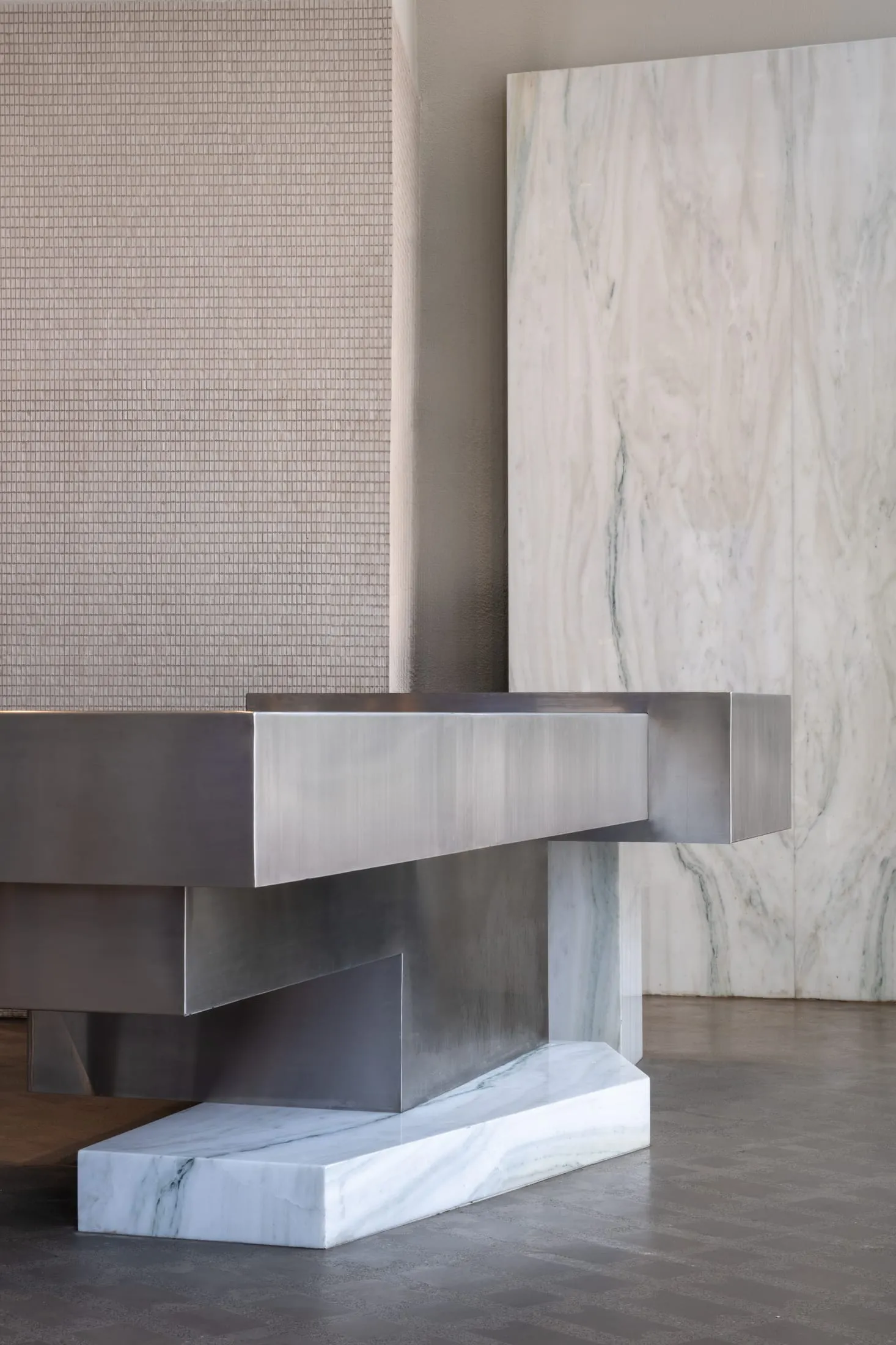 A modern interior space with a large stainless steel countertop, clean lines, and a minimalist aesthetic
