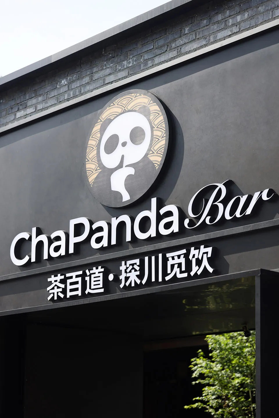Modern Asian restaurant with a concrete exterior and a black sign with white lettering