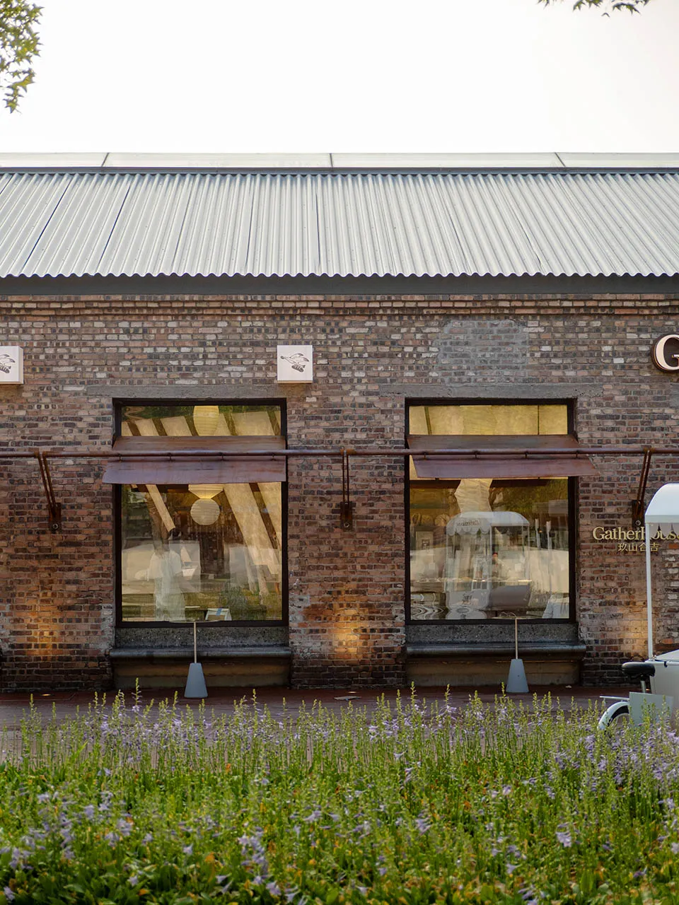 Old brick building with two large windows on each side of its facade, giving it a rustic appearance