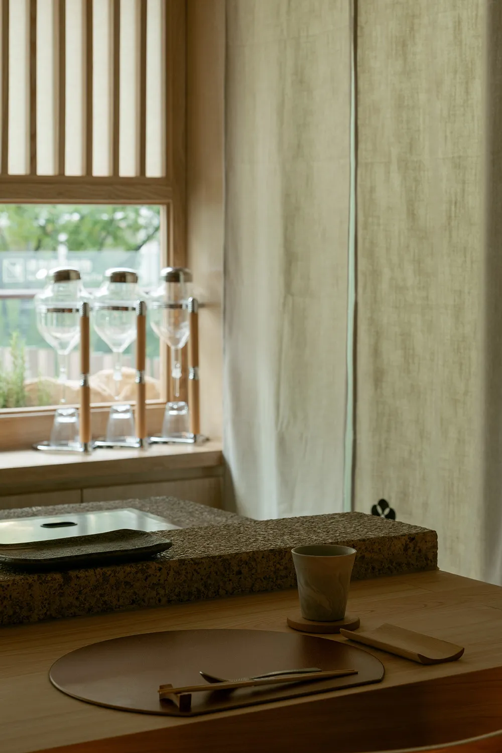 A calm kitchen scene with a sink, window, and wine glasses on a countertop