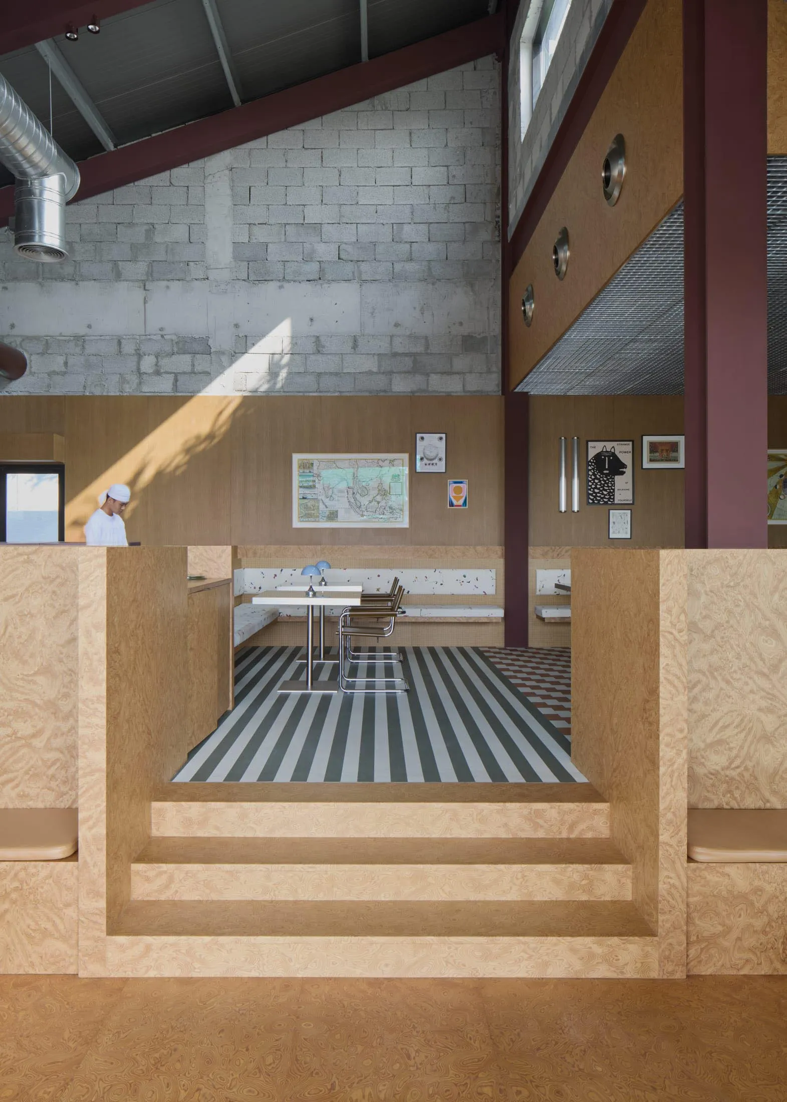 Dining area with wooden walls, two tables, and chairs, featuring a warm and inviting atmosphere