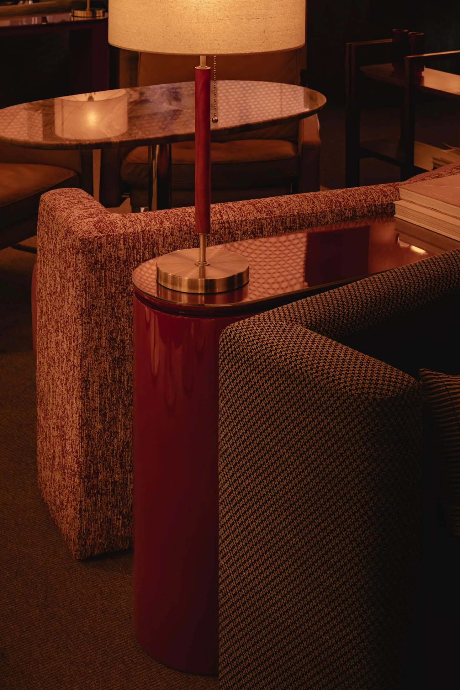 Cozy living area with a red table lamp, two couches, a dining table, and chairs, surrounded by inviting atmosphere