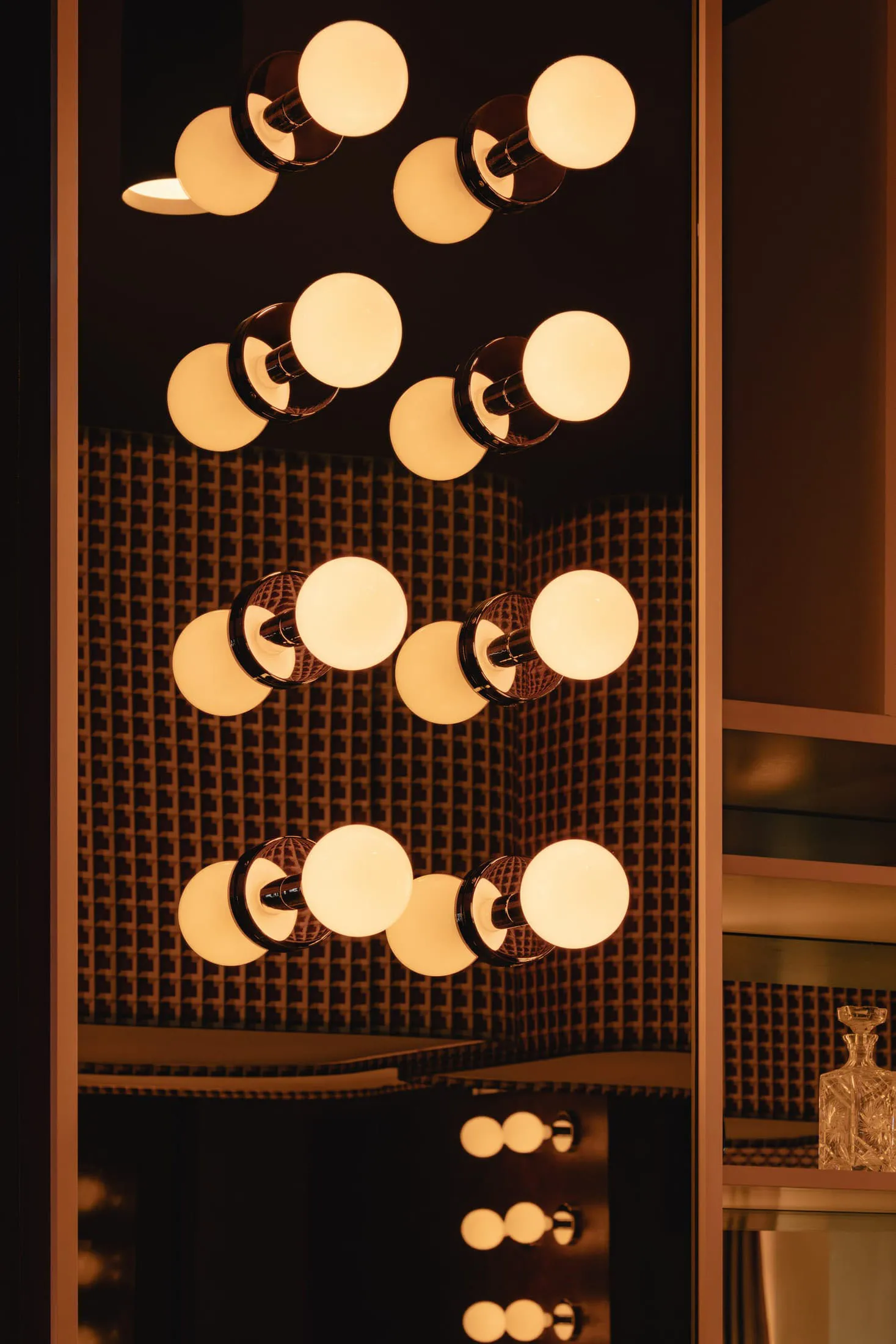 A well-lit bathroom with a large mirror surrounded by multiple lights, creating a bright and inviting atmosphere