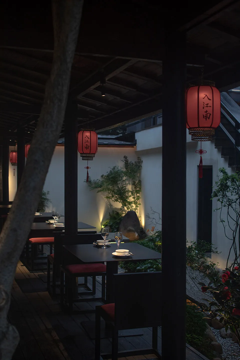 帶頂棚的露台用餐區，配有黑色桌椅、酒杯與悠閒氛圍