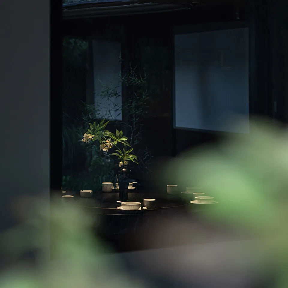 溫暖舒適的餐廳區域，設有餐桌、椅子及插花花瓶，周圍環繞植物與餐具