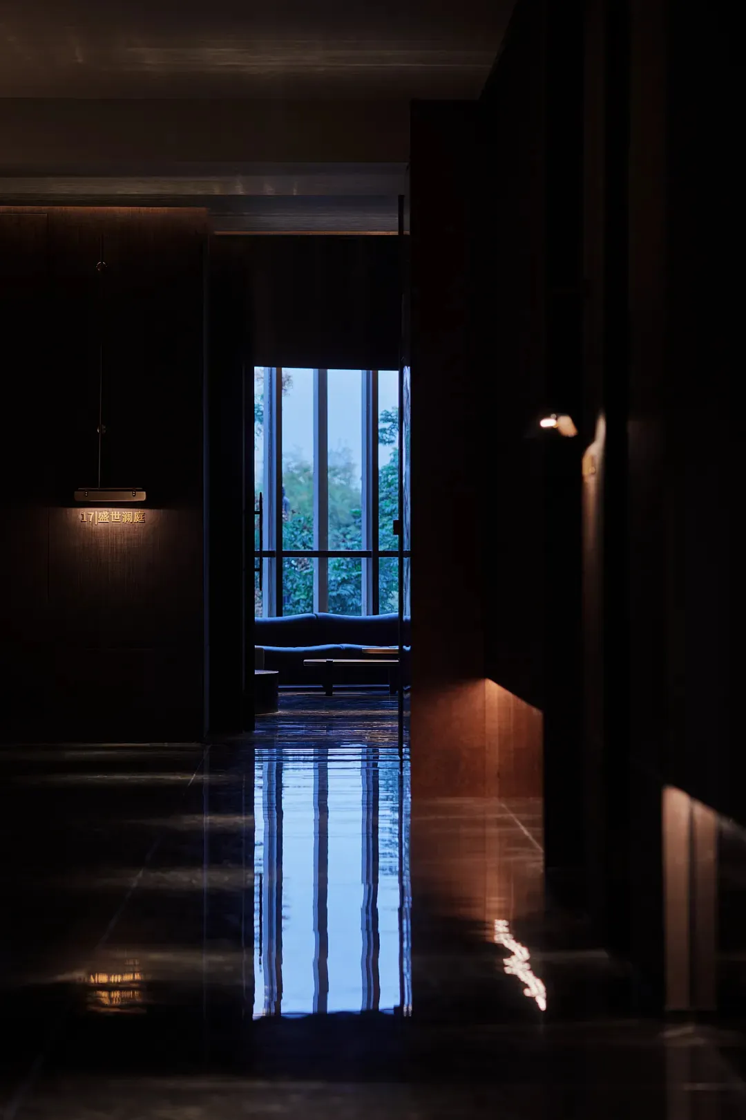 Empty hallway with wooden floor and walls, natural light from two windows on either side