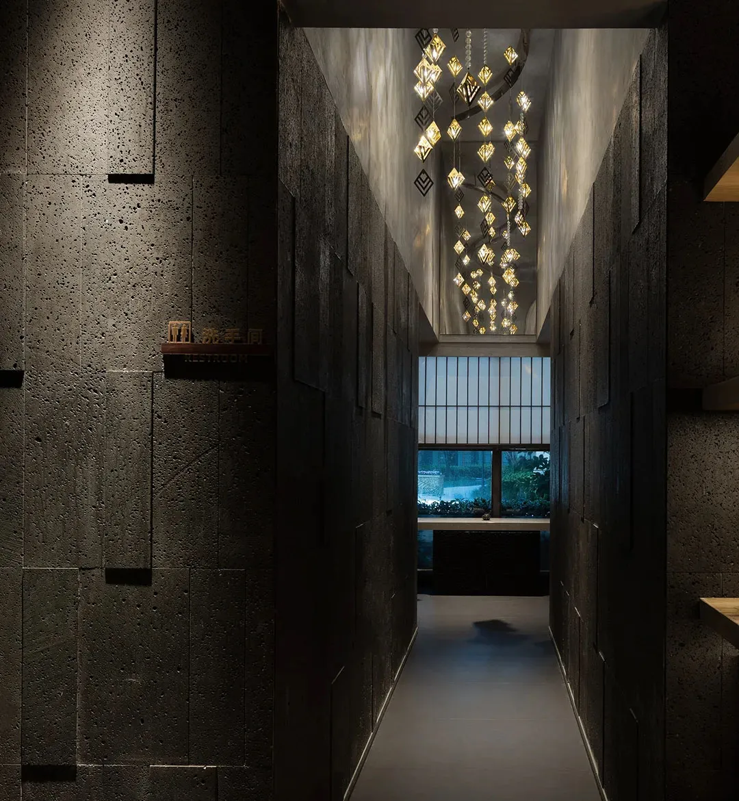A clean and well-maintained commercial hallway with a row of lights and potted plants