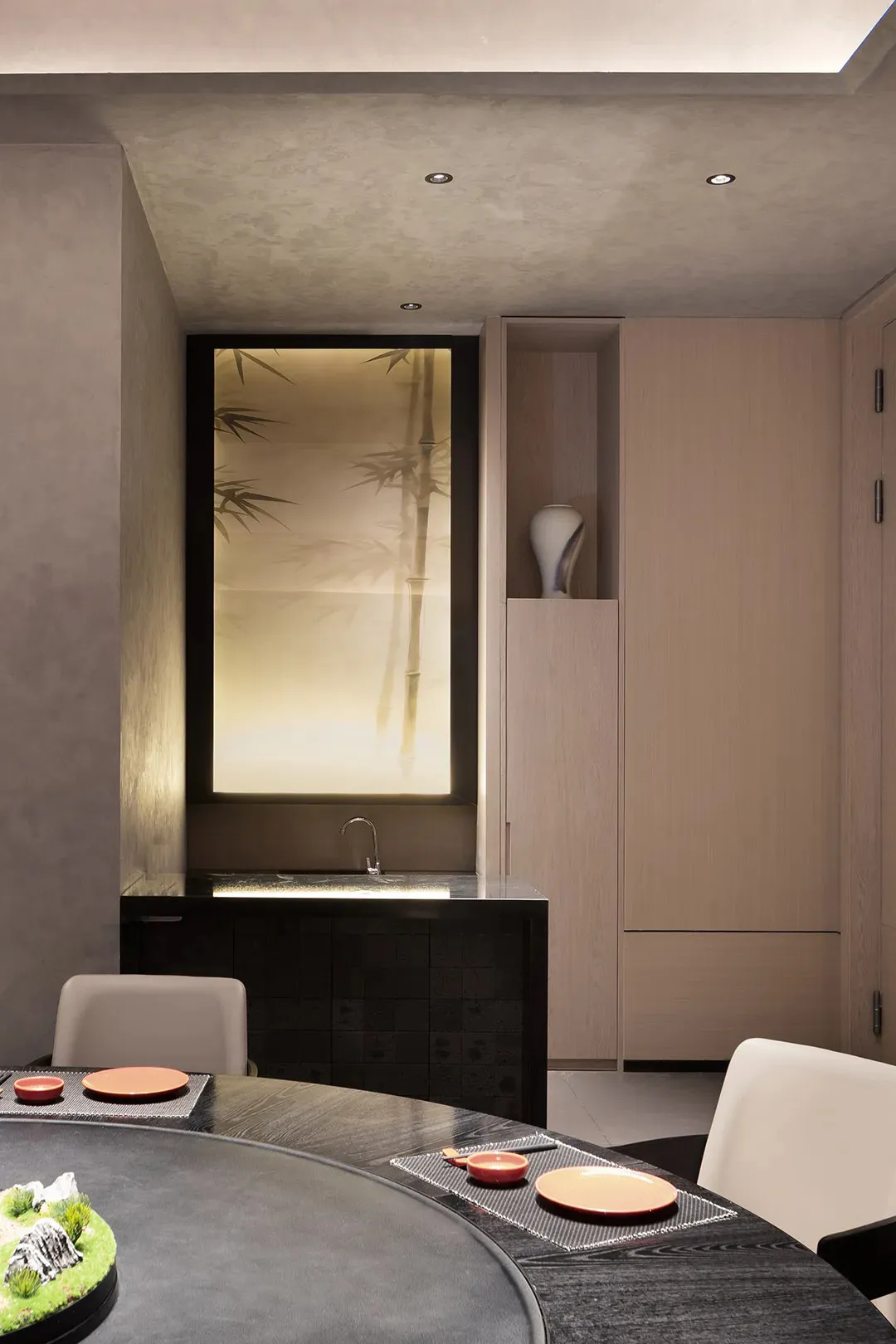 Modern bathroom with a sink area, wooden cabinet, glass door, and two chairs, in a minimalist and contemporary style