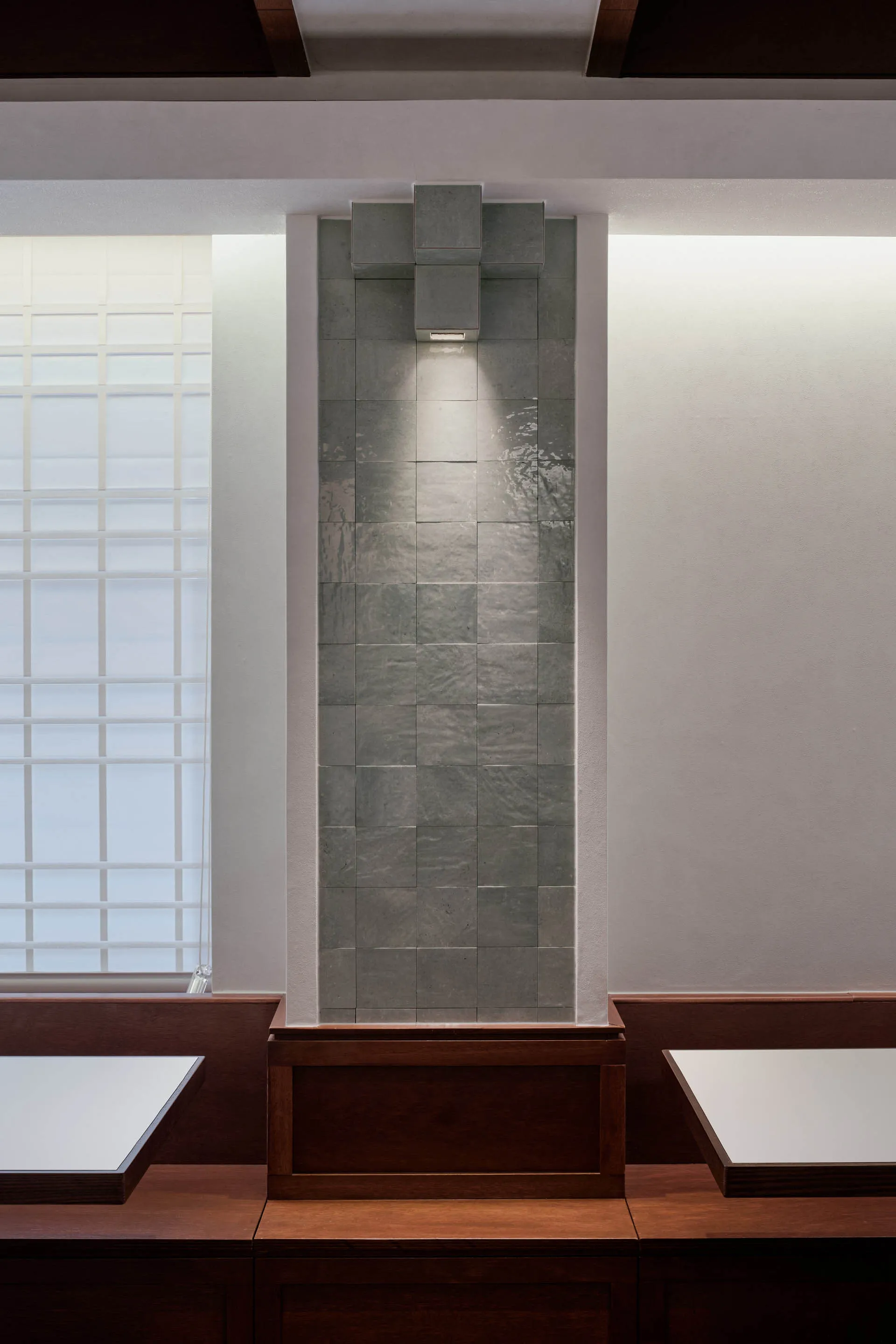 Elegant dining space with stone walls, tile patterns, and two dining tables, accompanied by a bench and chairs