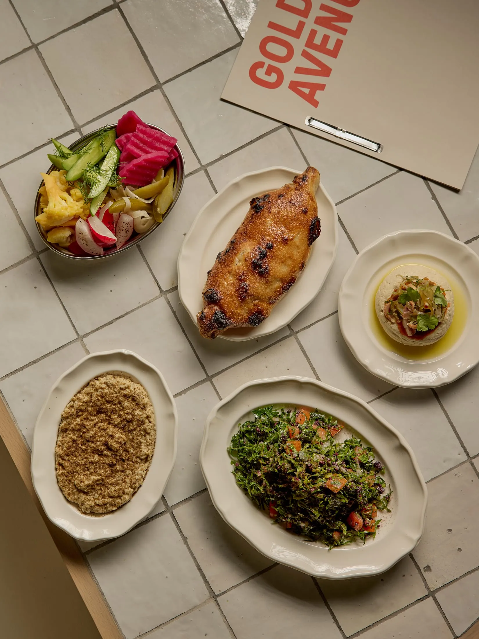 A dining table set with various plates of vegetables and bowls of food, creating a warm and inviting atmosphere