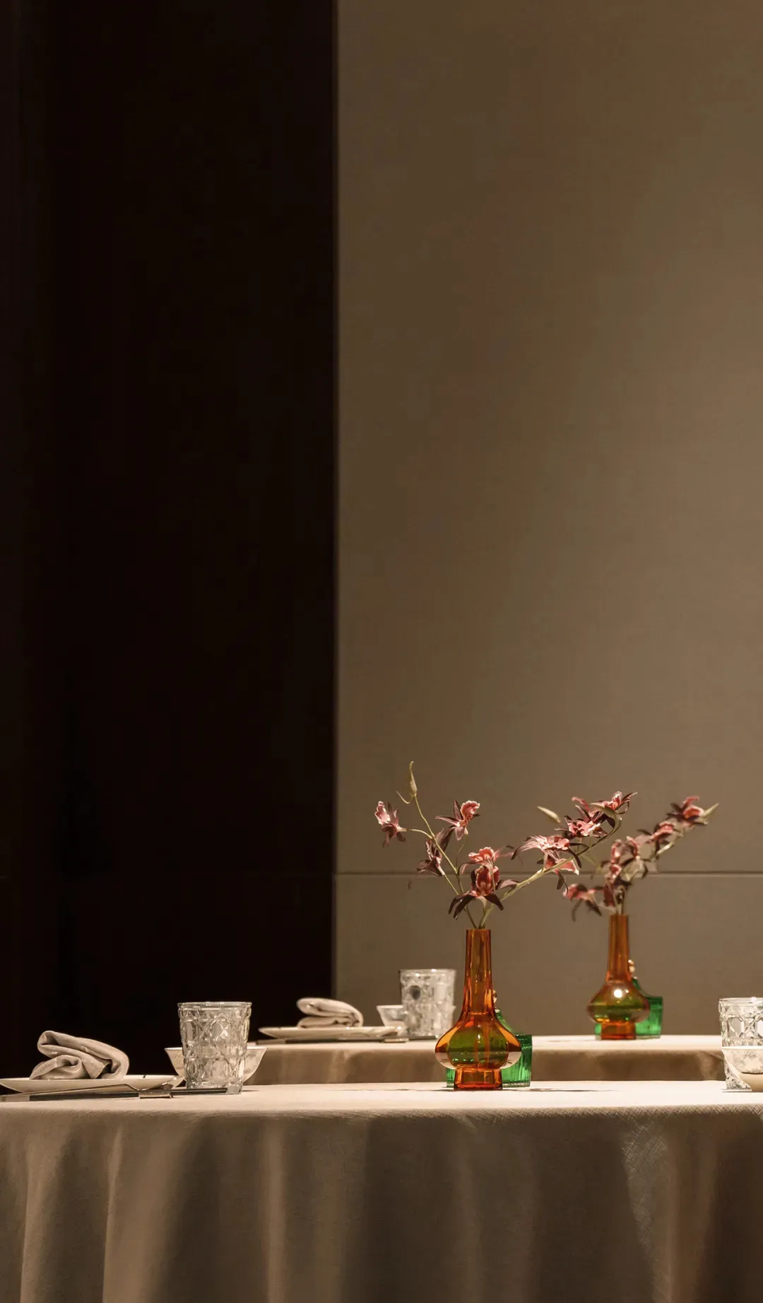 餐廳區域內擺設好餐桌，配有多個插花花瓶、餐具與杯具，營造出精緻而溫馨的氛圍